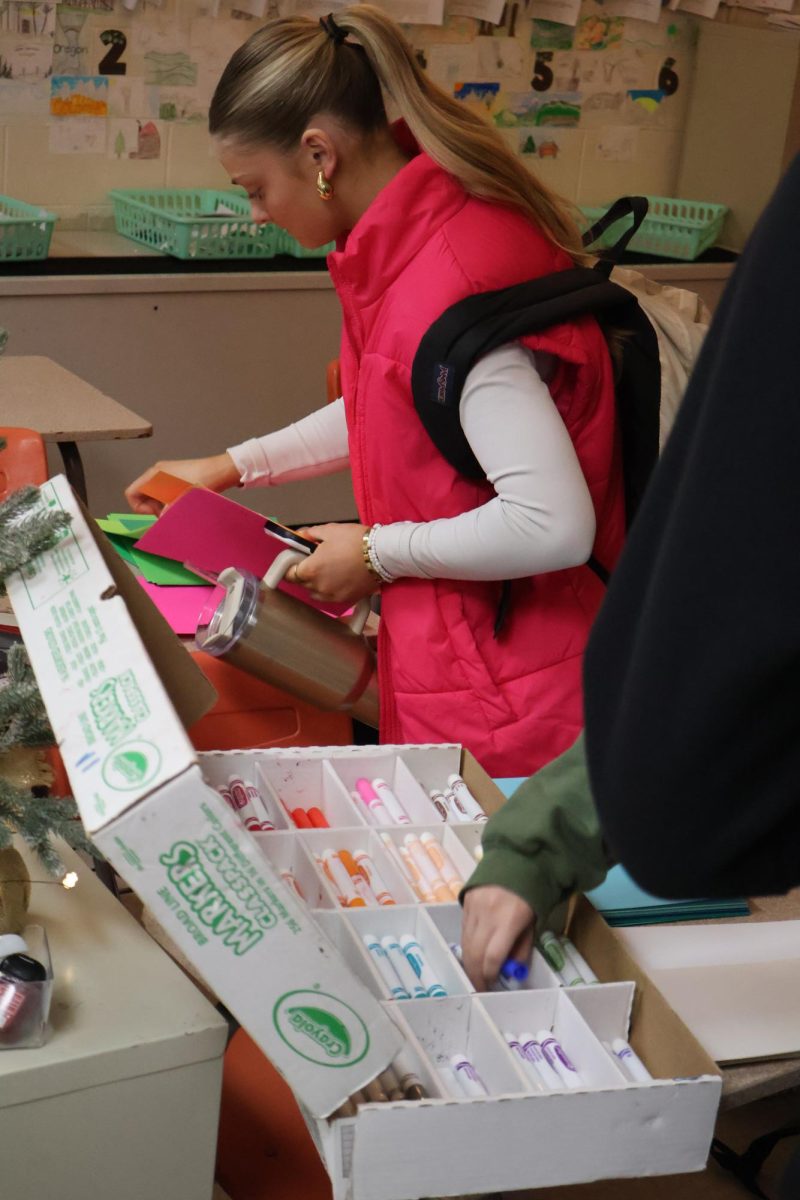 Looking for markers, senior Evie Metcalf picks out her colors. On Dec. 4, NHS made cards for the hospitals to give to them over the Christmas holiday. 
