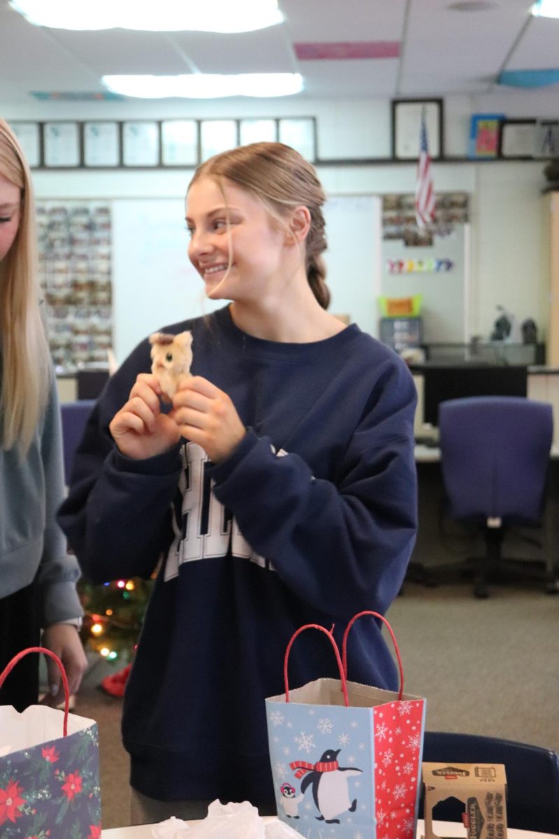 Showing off her new gift, Senior Evie Metcalfe participates in a White Elephant. On Dec.17, the yearbook staff holds a gift exchange to go into the holidays. 