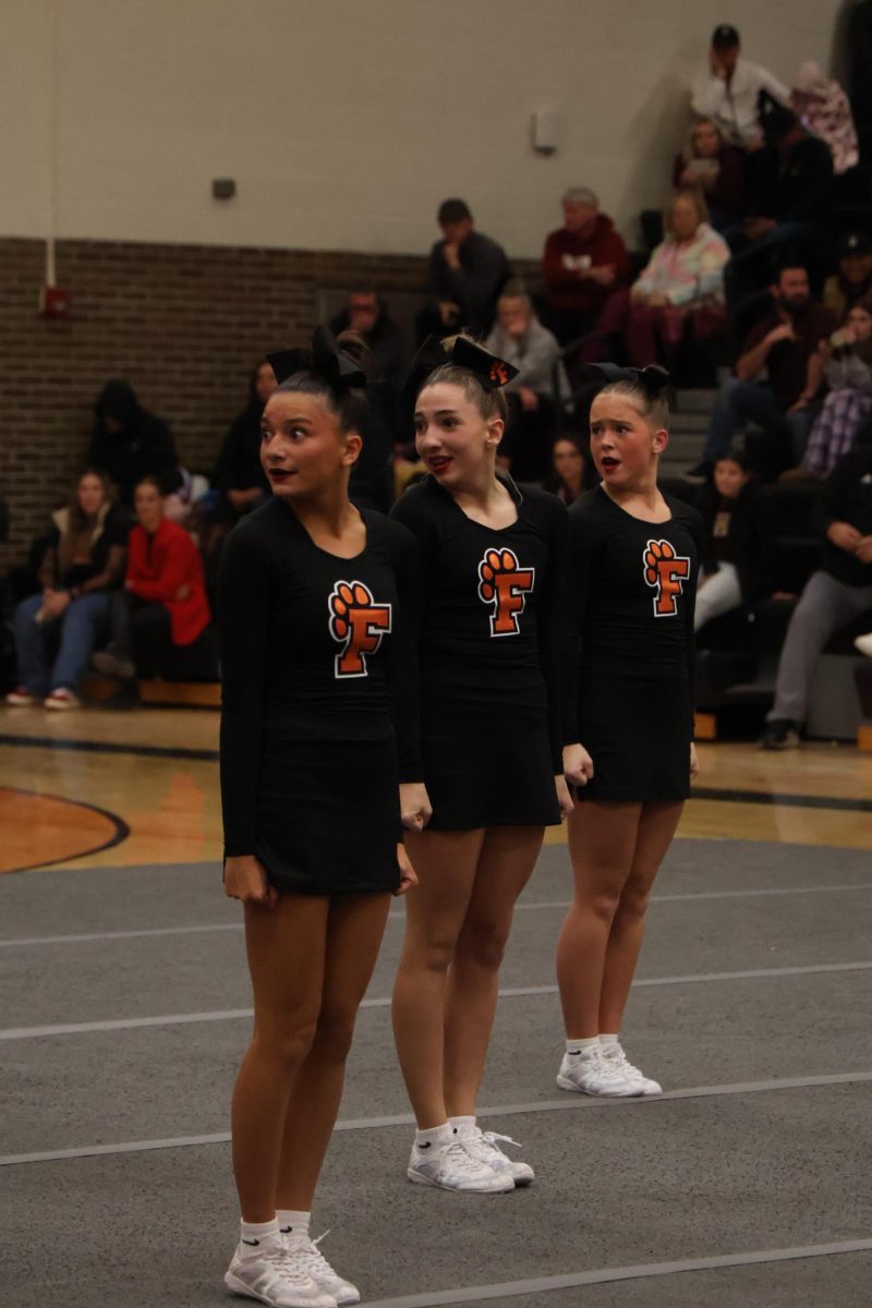 Focusing on the mat, junior Lily Brawner does her routine in front of the judges. The Fenton Cheer team competed in a cheer meet and placed in the top 3 in most rounds. 

