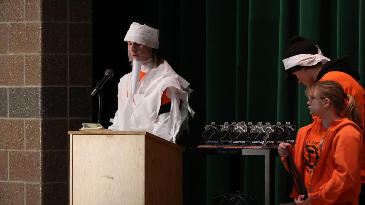 Speaking in front of a crowd, senior Caleb Wolner presents the robotics teams. On Dec. 6, the robotics team held an FLL competition at AGS middle school.