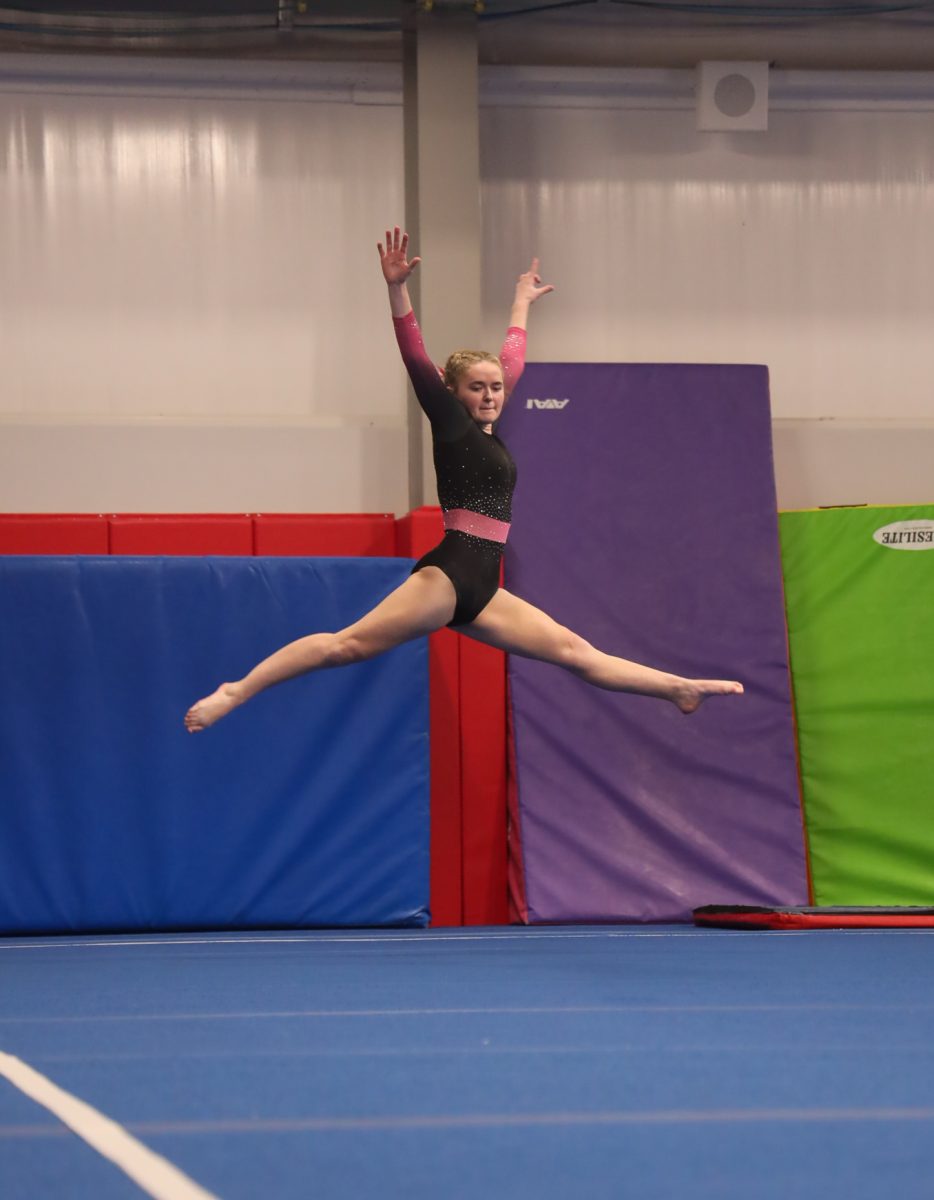 Doing a split jump, freshman Emery Obrien competes on floor. On Jan.10, Fenton competes against Haslett and scores an 8.375 on floor.
