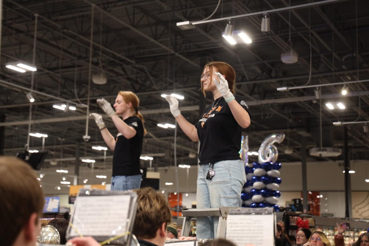 Conducting the music, junior Michaela Wolbert leads the band in playing the fight song. On Jan. 20, the Fenton Marching Tigers plays at Kroger's grand opening.