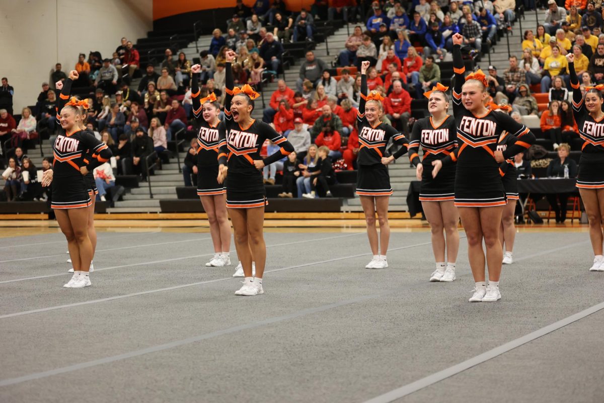 Showing excitement, sophomore Laine Derwin and junior Lilly Brawner are doing their cheer routine. Fenton placed top 3 in all rounds in the Cheer Comp.