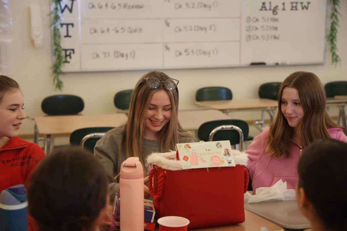 Smiling, senior Ava Vorheis accepts her gift from the dance team. On Dec. 19 the dance team had a party with secret santa and other games.