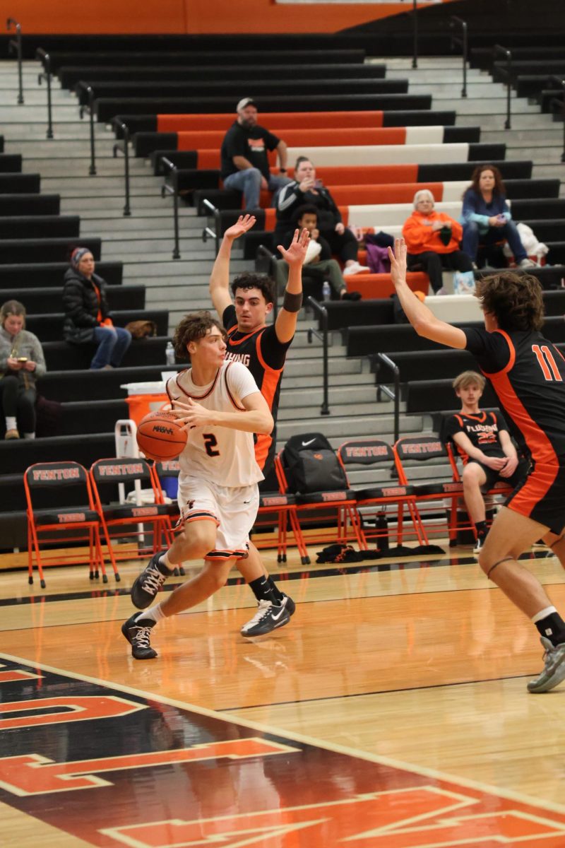 Running down the court, sophomore Gavin Freeman prepares to pass the ball. On jan 15 Jv boys basketball played flushing. 