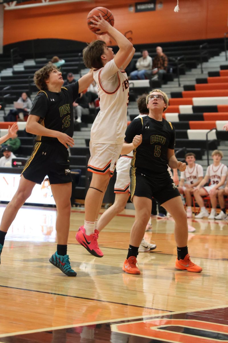  Going up for the shot, sophomore Colten Moore shoots the ball. On Jan 21, Fenton JV boys' basketball played H.H. Dow and won 66-62. 

