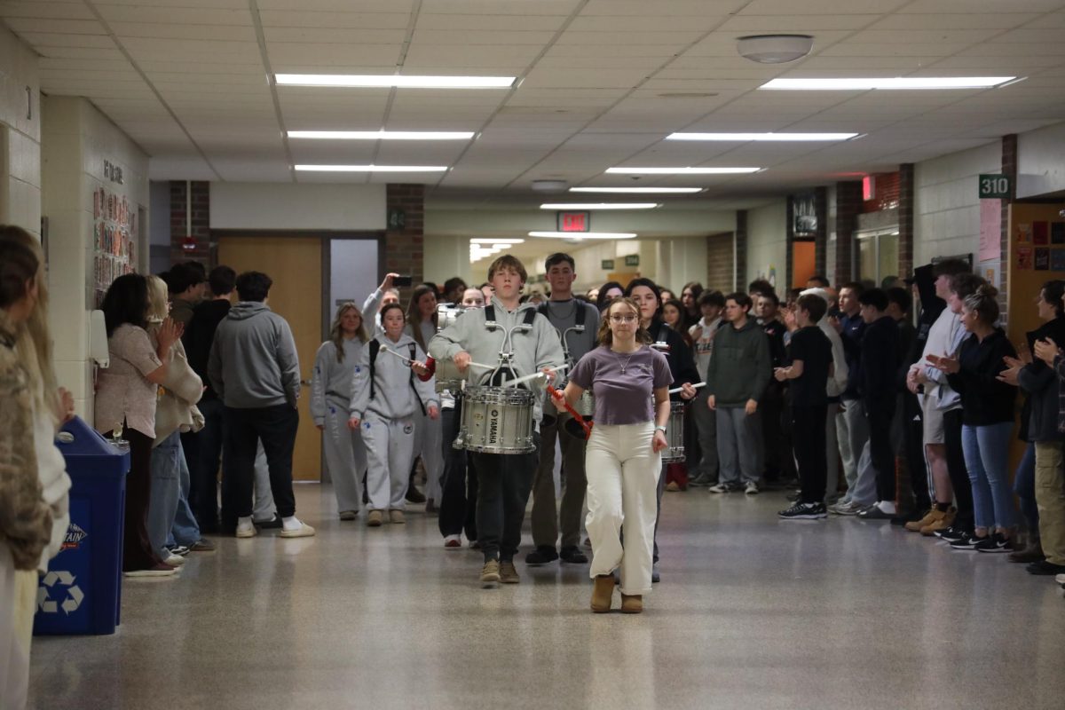Walking down the hall, the band escorts the Fenton girls ski team.  On Feb. 19, the girls ski team got honored for making it to states. 
