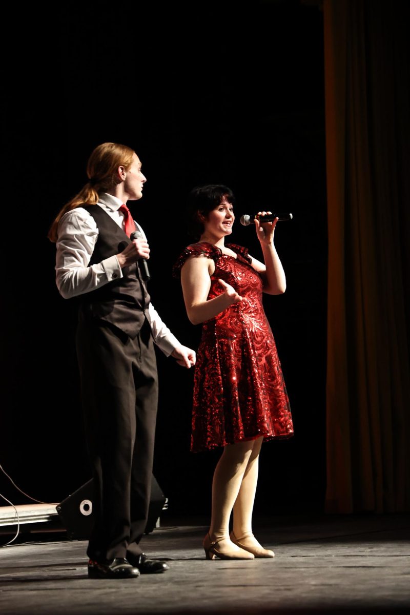 Introducing their show, seniors Amelia Grasso and Ash Holmes are talking to the audience. On Feb. 21 The Fenton Ambassadors started their concert for family and friends who watched from the audience 
