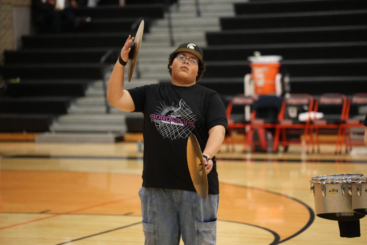 Looking at the crowd, junior Lukas Perczak plays a percussion instrament. On Feb. 3, the winterline performed during halftime of the Fenton girls varsity basketball game. 



Looking at the crowd, junior Lukas Perczak plays a percussion instrament. On Feb. 3, the winterline performed during halftime of the Fenton girls varsity basketball game. 



Looking at the crowd, junior Lukas Perczak plays a percussion instrument. On Feb. 3, the Fenton winterline performed during halftime of the girls varsity basketball game.