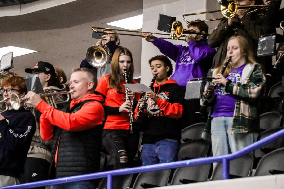 Reading the music while playing, juniors Eliza Shier and Eva Douglas play with the band. On Jan 31 the band plays at the griffins senior night hockey game. 