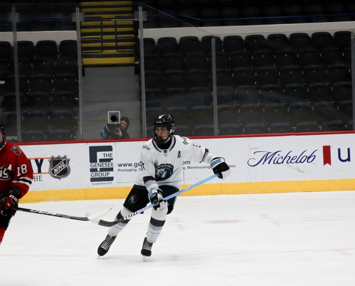 Ready to get the puck, junior Trent Rockmen plays in an intense hockey game. On Jan 31, the Griffins hockey team vs Freeland High School and lose 5-3.
