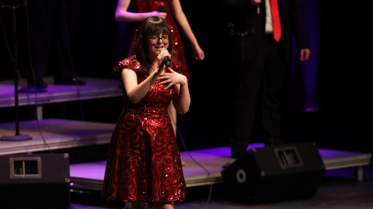 Singing, junior Wendy Thibodeau performs in front of an audience. On Feb. 21, the FHS ambassadors held their show Back By Popular Demand in the auditorium.