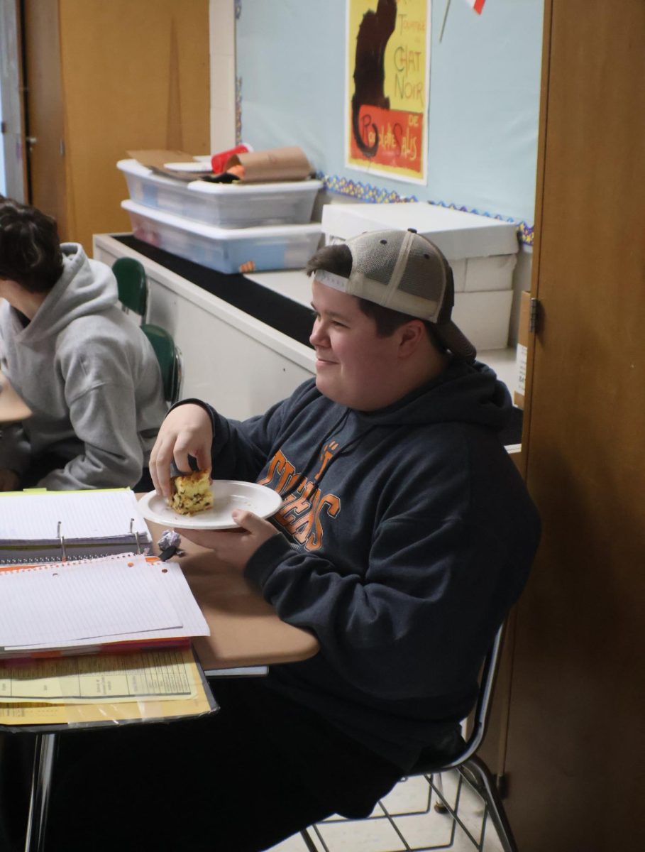 Eating a pastry, sophomore Cameron Bradley participates in his french classes party. On Feb. 4, all French classes at Fenton High participated in a food day to celebrate French cuisine.