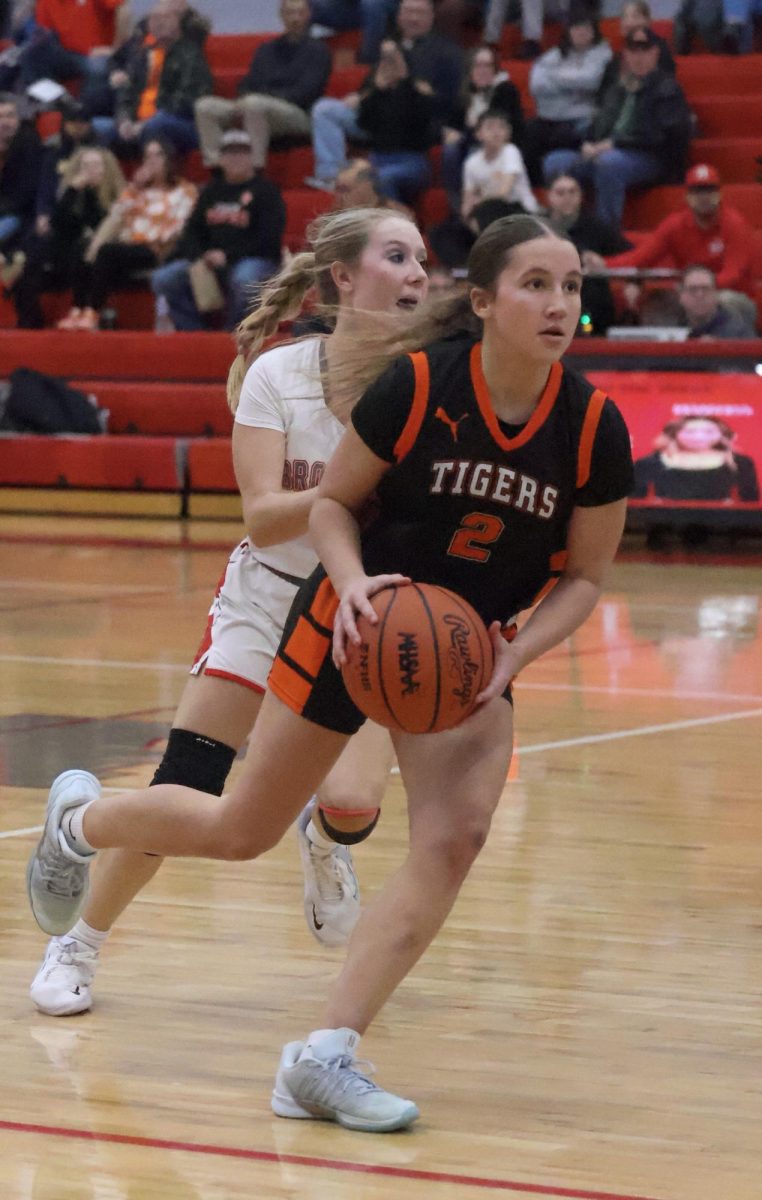 Looking to her teammates, junior Maddie Eltringham gets ready to pass the ball. On Jan. 30, girls varsity basketball played against Holly and won 67-20.