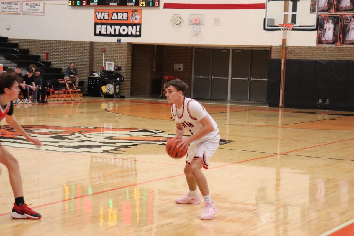 Dribbling the ball down the court, sophomore Carson Bender is looking to see who is open. On Jan. 29, the Fenton Tigers JV boys basketball team lost to Holly 63-44. 
