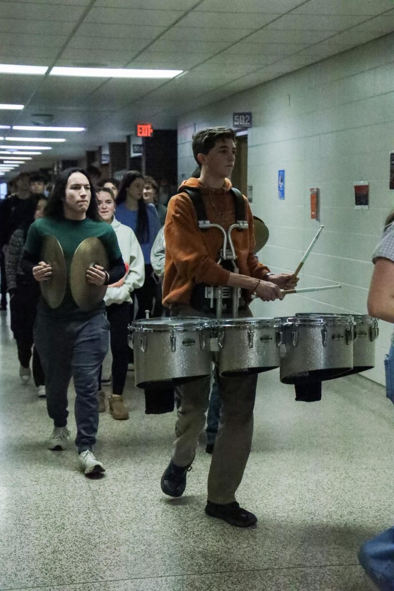 Walking the halls, junior Klayton Yoerg plays the drums for a clap out. On March 5, the DECA and wrestling team had a clap out for going to states.