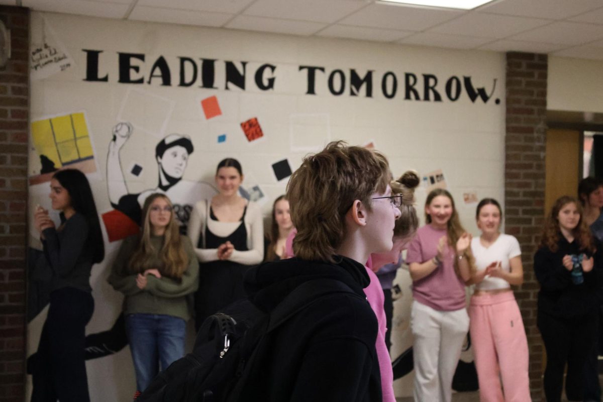 Looking ahead, junior Madison Rush walks through the cheering halls. On March 20, the figure skaters going to states were clapped out. 