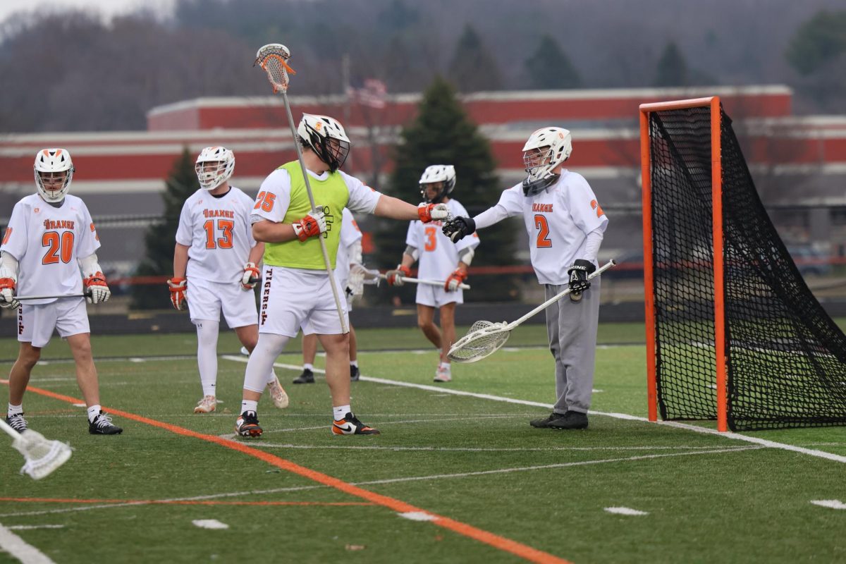 Giving a fist bump, junior Cooper Ford and senior Jacob Henson are warming up before their game. On March 20, Fenton plays against Swartz Creek and ends the game with a win of 8-7
