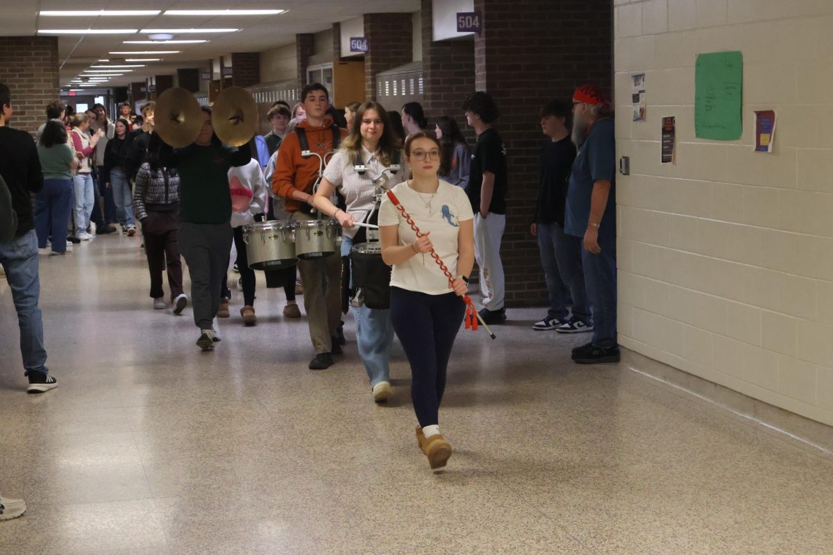 Leading the band, junior Michaela Wolbert escorts the DECA and wrestling teams. On March 5, these teams got honored for making it to states.

