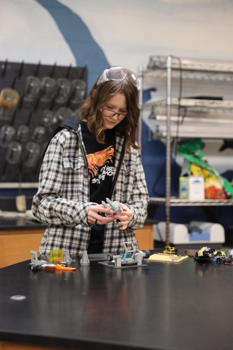 Building Legos, freshman Ellary Davis attempts to make a bridge. On April 7, during SRT students built lego bridges. 