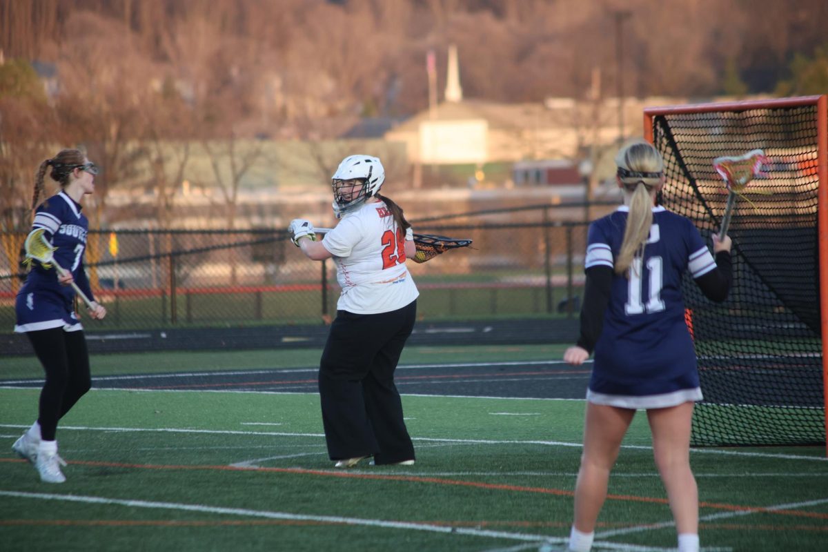 Staring her opponents down, senior Kayla Kinney stops the ball. On April 7, the girls' varsity lacrosse team played South Lyon and lost 3-18.
