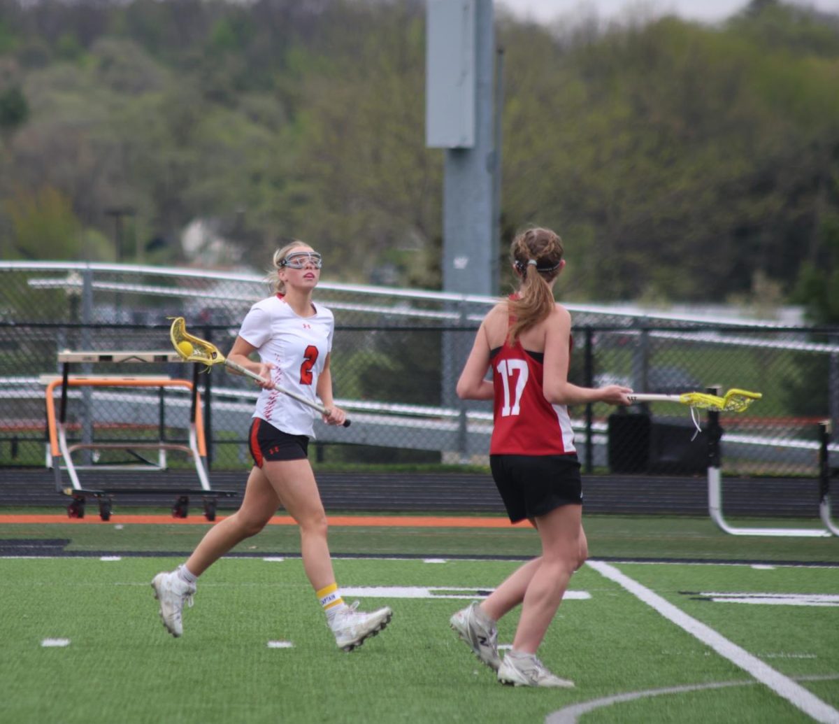 Looking at her opponent, senior Kallyn Sprague attempts to make a goal. On April 27, the girls varsity lacrosse team played Swartz Creek and won 19-0. 