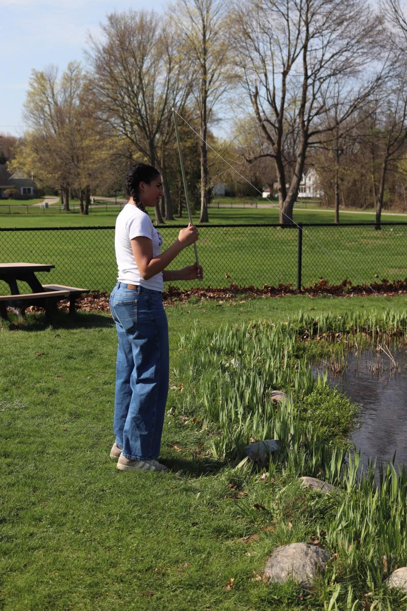 Waiting to catch a fly, shopmre Joelle Sababa is trying out her fly pole. On April 21, science teacher Matt Sullivan had SRT students make fly fishing poles and use them to fish in the pond.
