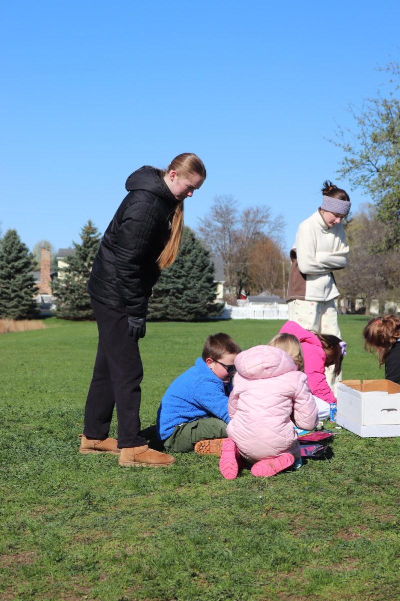 Playing with the kids, Sophomore Brinley Canada, is teaching the kids about nature. On April 20, the Eco club hosted pond day for State Road Elementary 
