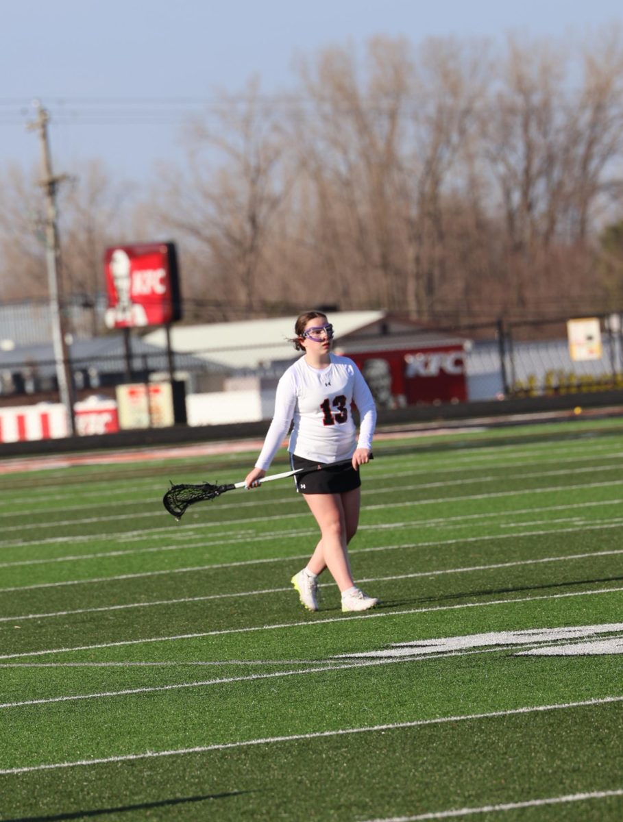 Walking towards her net, freshman Charlie Livingston is helping her team win a Lacrosse game. On April 8, the girls JV Lacrosse team won their game against South Lyon 11 to 5.