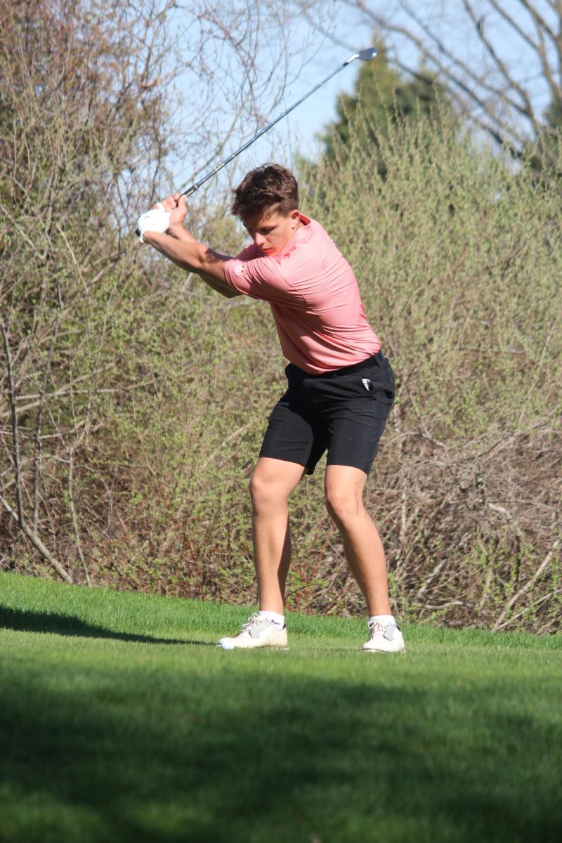 Eyes on the ball, senior Nate Fuller tees off. On April 17, the boys varsity golf team won with a score of 173 to Swartz Creek's 197.