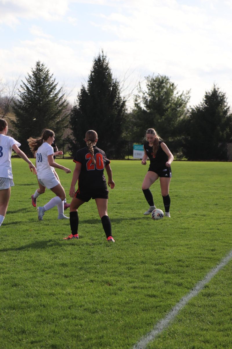 Receiving a pass, sophomore Emery Malnati plays with her team in a high-stakes game. On April 14, the Fenton girls JV soccer team  plays against Marian High School and loses (finding out score)