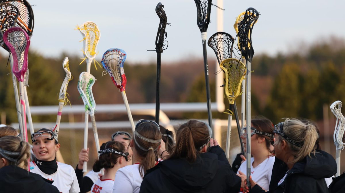 Cheering their team on, the girls varsity lacrosse team raise their sticks in celebration. On March 25, Fenton went up against Clarkston and lost 10-12.