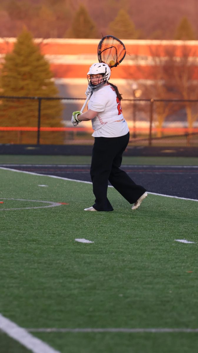 Defending, senior Kayla Kinney blocks opponents from shooting.  On April 8, the girls varsity lacrosse went up against South Lyon and lost 3-18.