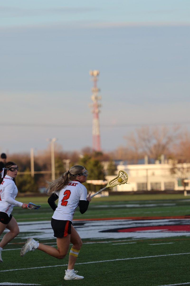 Running with the ball, senior Kallyn Sprague takes the ball down the field. On April. 8 the girls varsity lacrosse team had a meet against South Lyon.  