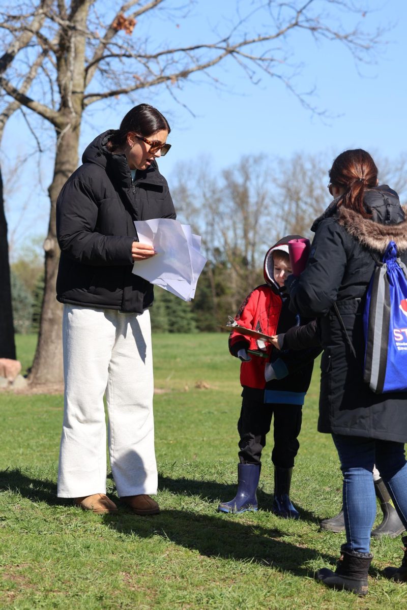 Passing out papers, junior Campbell Dean volunteers at Pond Day. On April 20, Fenton Eco Club held pond day ot the high school. 

