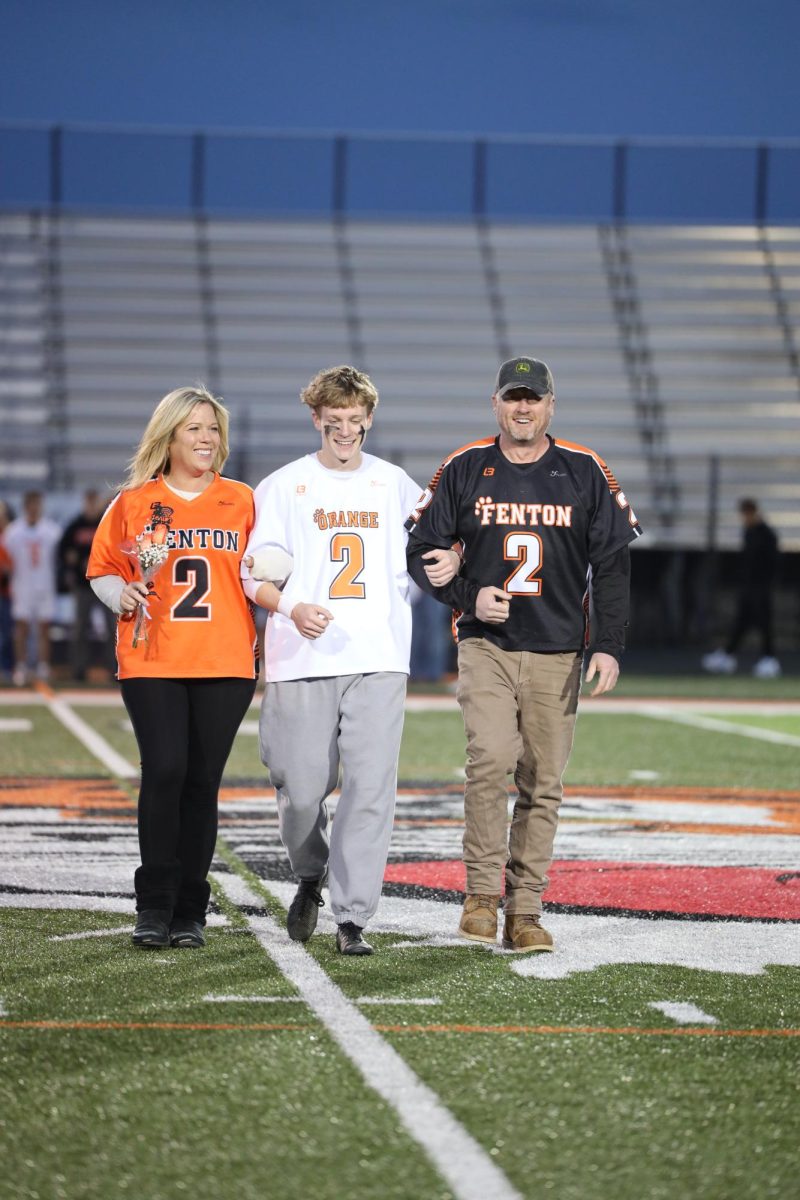 Walking down the field, senior Jacob Henson leads his parents. On May 15, the Varsity Boys Lacrosse had their senior night.
