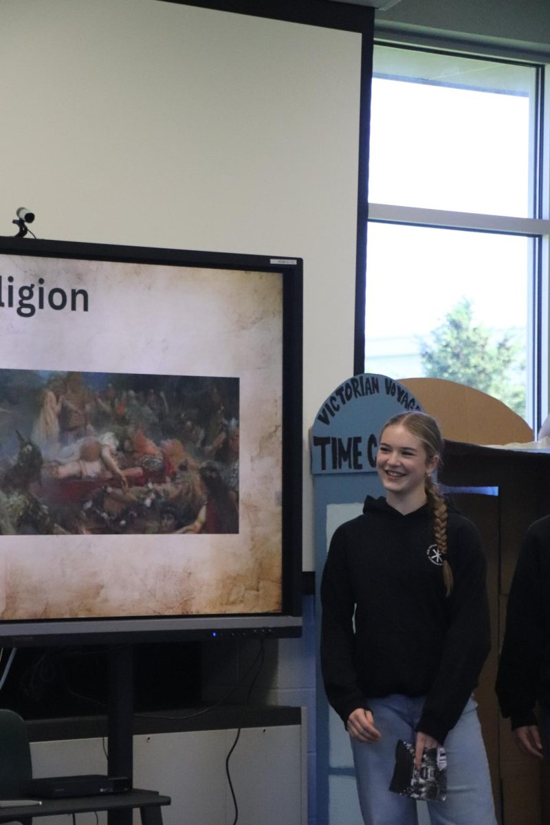 Completing her presentation, freshman Rosalind Roesner does her presentation for her honors time capsule. On May 21, the freshmen honors class did a time machine presentation.